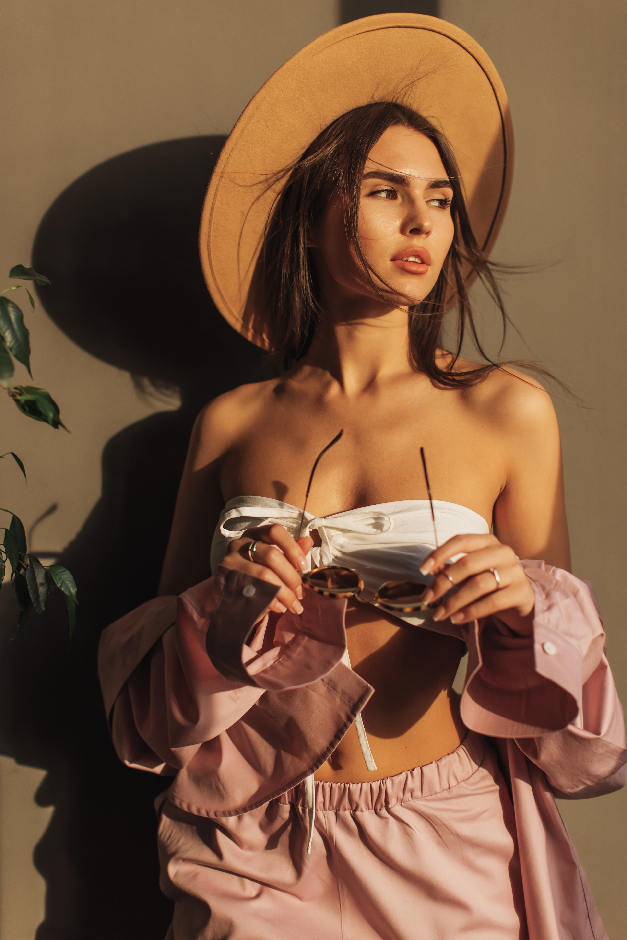 Model in fashion outfit with sunglasses and hat.